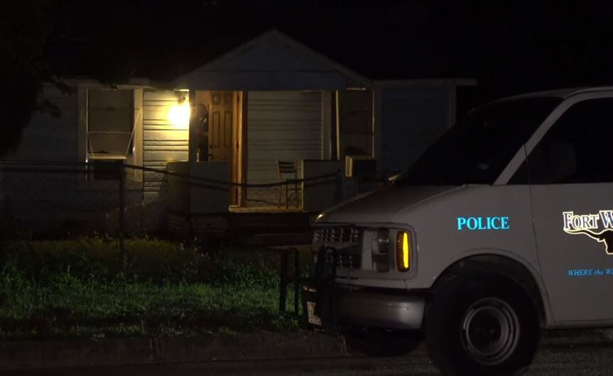 A Fort Worth police van sits outside a home where a man was injured in a stabbing Friday morning.