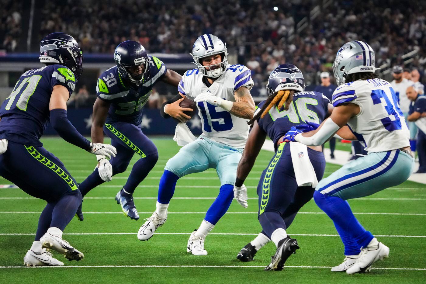 Dallas Cowboys quarterback Will Grier (15) scrambles for yardage between Seattle Seahawks...