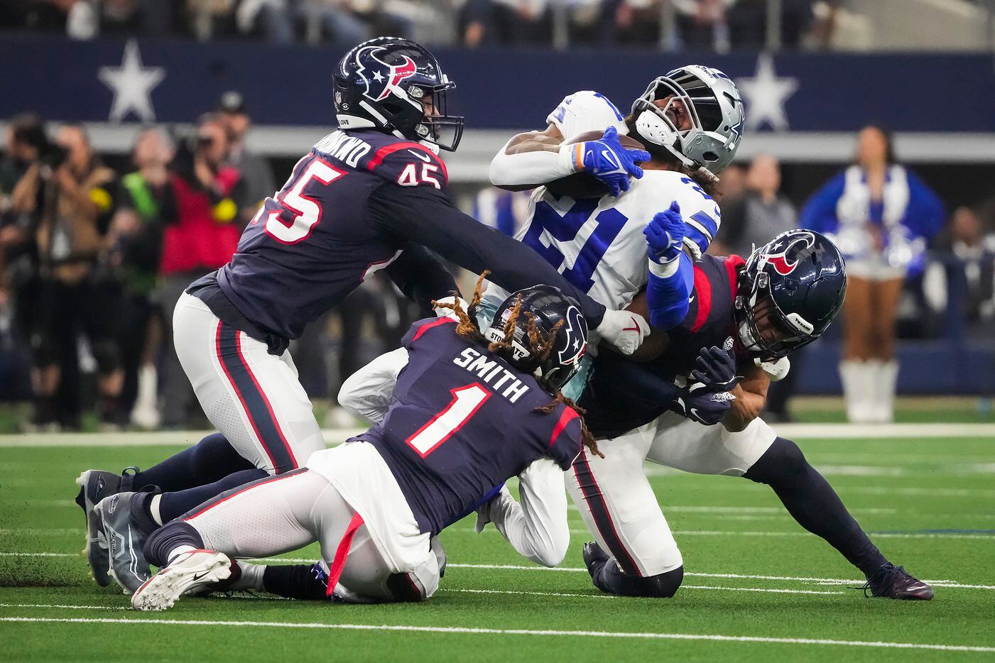 Dallas Cowboys running back Ezekiel Elliott (21) is brought down by Houston Texans...