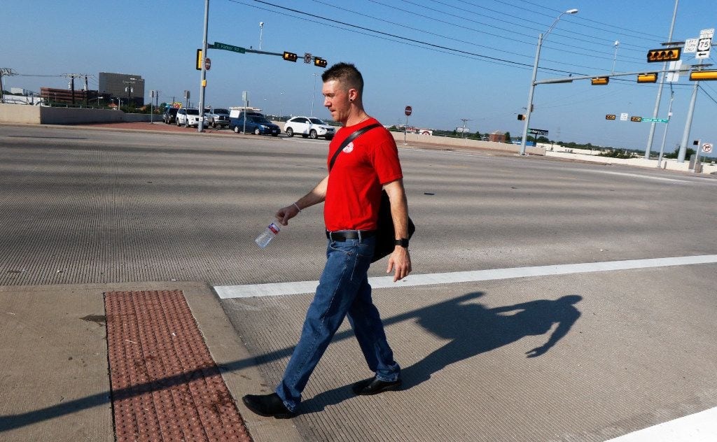 Corey Ahrens walks across U.S. 75 in Plano after leaving his home in Plano. 