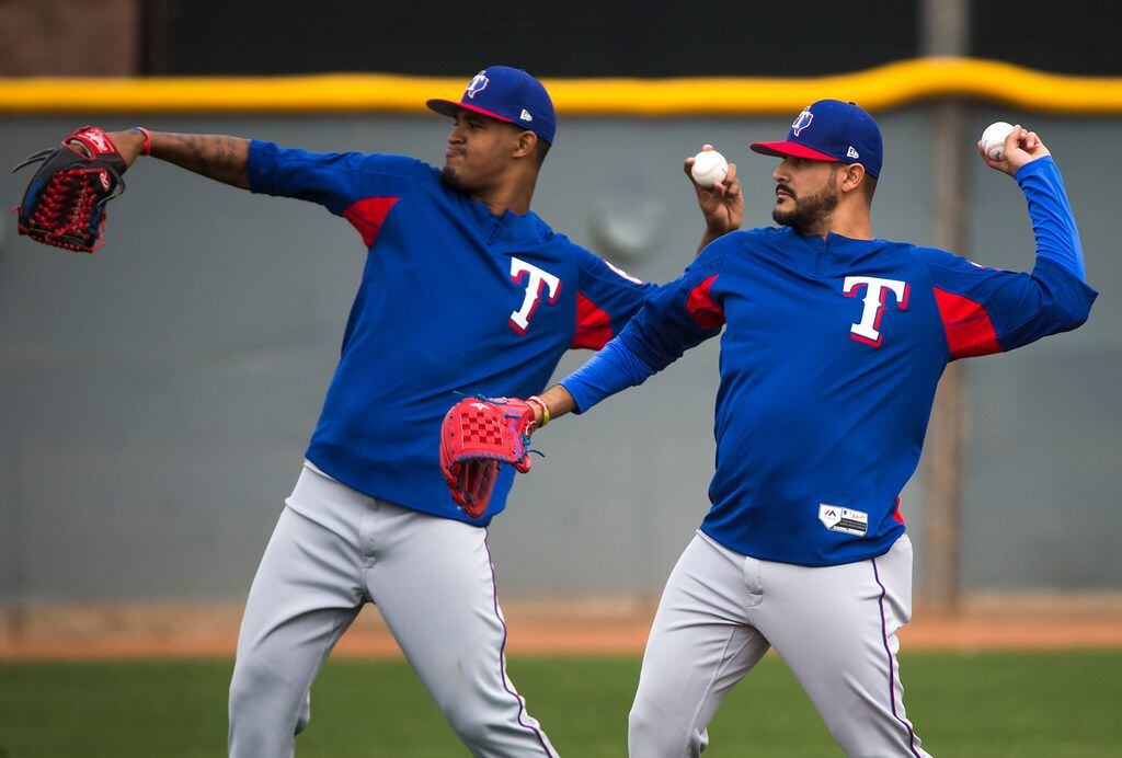 Texas Rangers pitchers Martin Perez (right) and  Yohander Mendez long toss during the first...