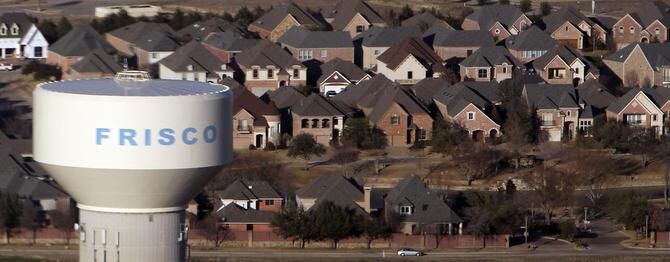 An aerial view of a Frisco water tower rising over a new housing development in Frisco in...