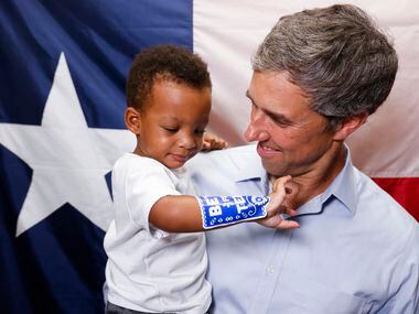 Texas Governor candidate Beto O'Rourke, right, looks towards Hayden Hammonds, 1, as takes a...