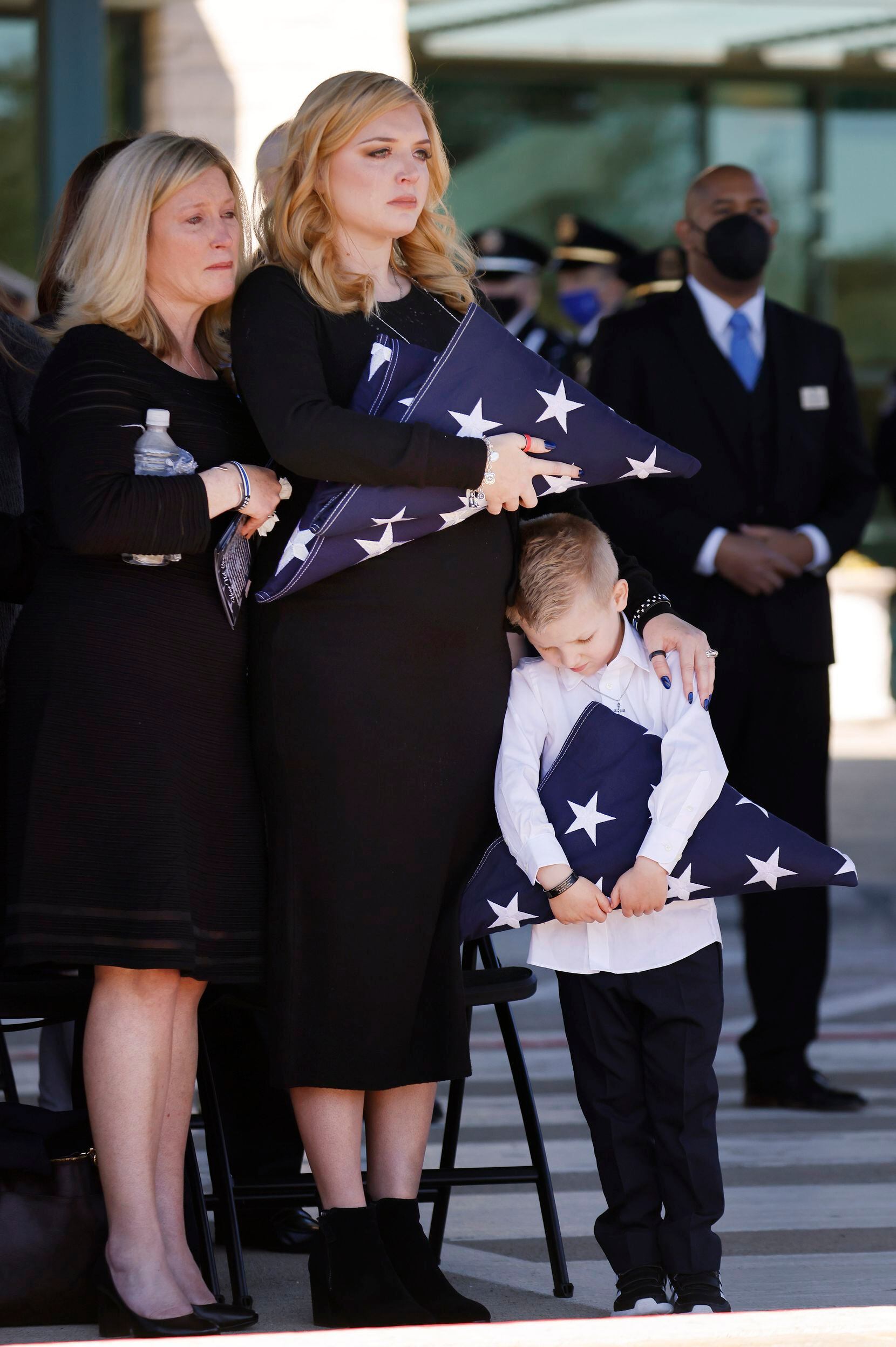 Penton’s widow, Noel Bergenske Penton (center), and son, Cashton, gripped folded U.S. flags given to them by Dallas police Chief Eddie Garcia after the funeral service  Feb. 22 at Prestonwood Baptist Church.
