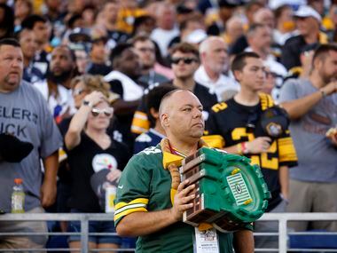 A Green Bay Packers fan holds his Lambeau Field hat over his heart during the playing of the...
