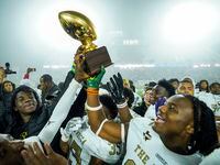 South Oak Cliff players celebrate with the game trophy following a victory over Argyle in a...