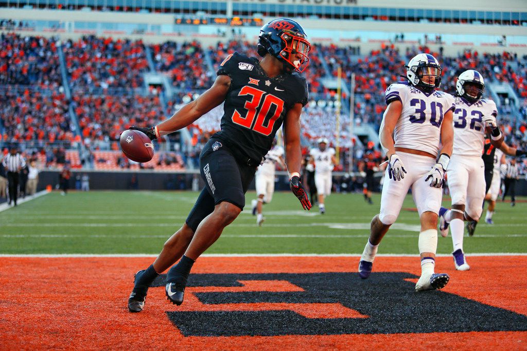STILLWATER, OK - NOVEMBER 2:  Running back Chuba Hubbard #30 of the Oklahoma State Cowboys scores on a 62-yard run against linebacker Garret Wallow #30 and defensive end Ochaun Mathis #32 of the TCU Horned Frogs on November 2, 2019 at Boone Pickens Stadium in Stillwater, Oklahoma. OSU won 34-27.  (Photo by Brian Bahr/Getty Images)