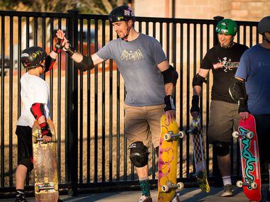 Clinton Haley high-fives his son Travis Haley, 9, after as they skateboard at Lively Pointe...