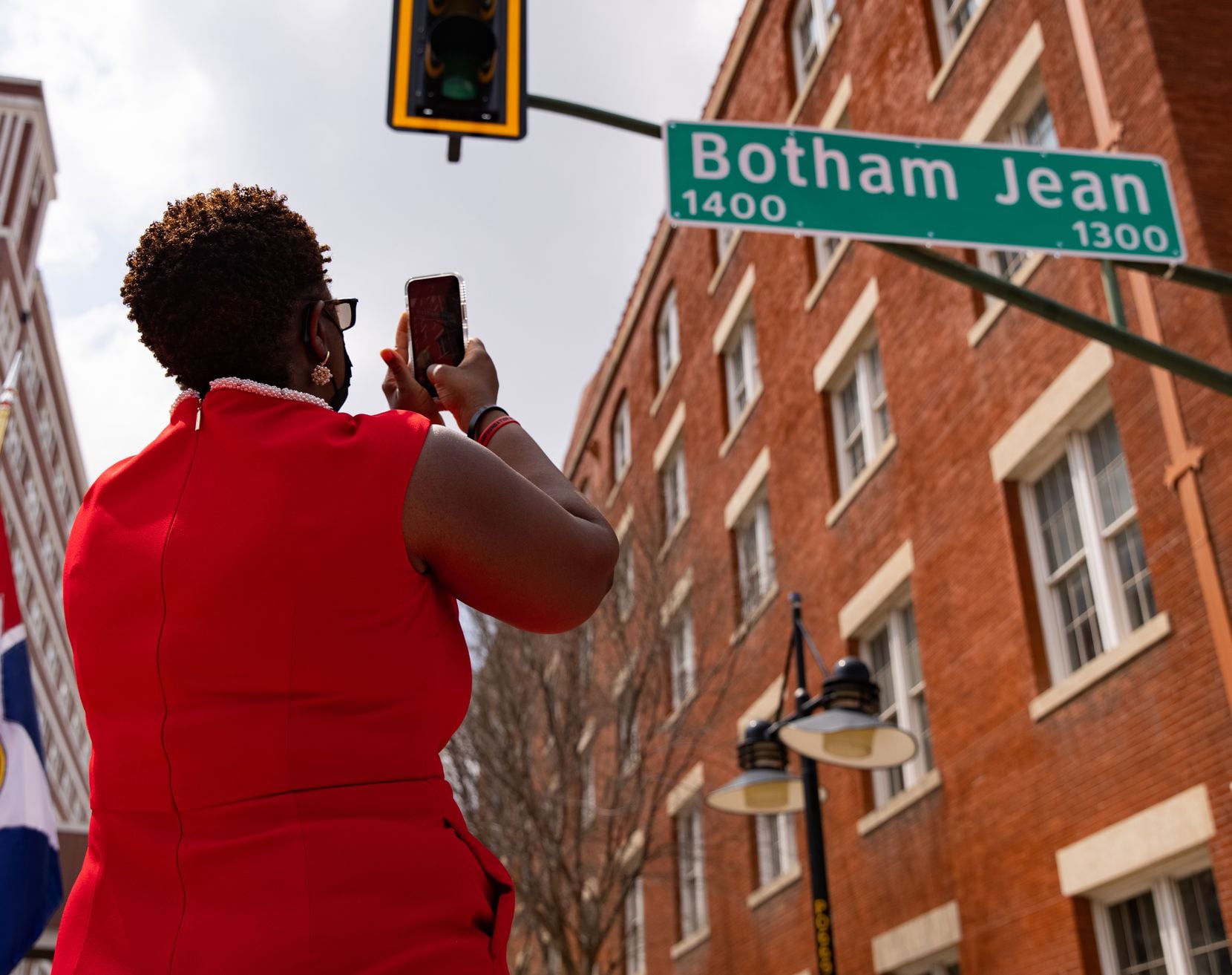 Botham Jean's mother, Allison Jean, takes a photo of a sign bearing his name at a ceremony to redub a four-mile stretch of Lamar Street in his honor Saturday, March 27, 2021.