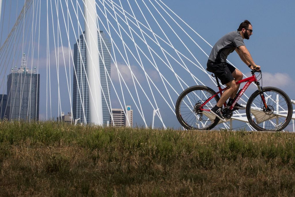 A cyclist passes the Margaret Hunt Hill Bridge while riding on the Trinity Skyline Trail in...