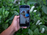 Mynor Cardona shows a photo on his cellphone of her daughter, Yenifer Yulisa Cardona Tomás,...