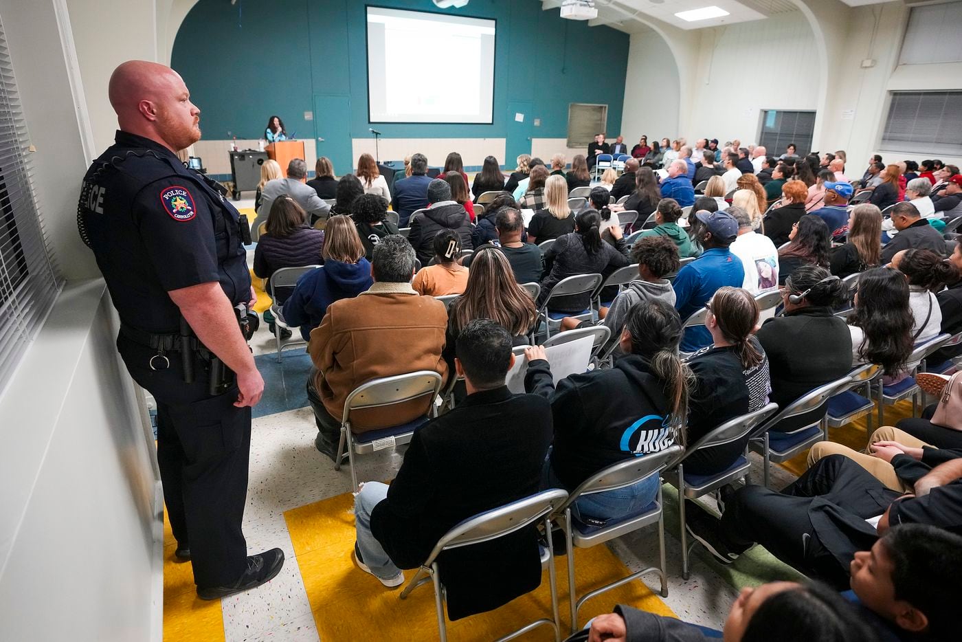 A Carrollton police officer stands to the side of the room during a Student Health Advisory...