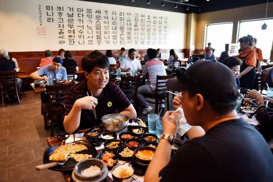 Chan Woo, 22, and Andy Kin, 46, both of Lewisville, enjoy lunch at BCD Tofu House in...