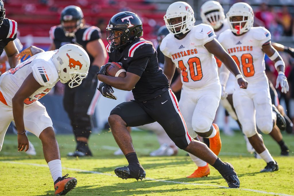 Euless Trinity running back AJ Barnett (5) breaks through the Sachse defense on his way to a...