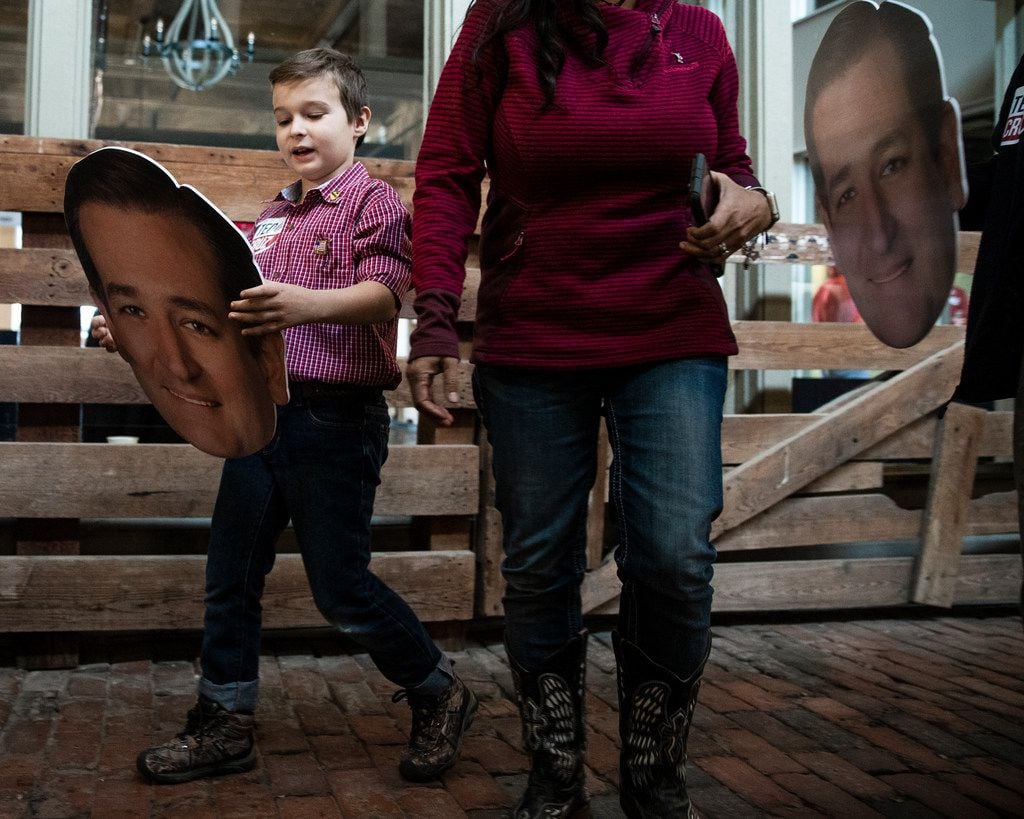 Ian Williamson 9, of Fort Worth, carries a cutout picture of Senator Ted Cruz's head as he...