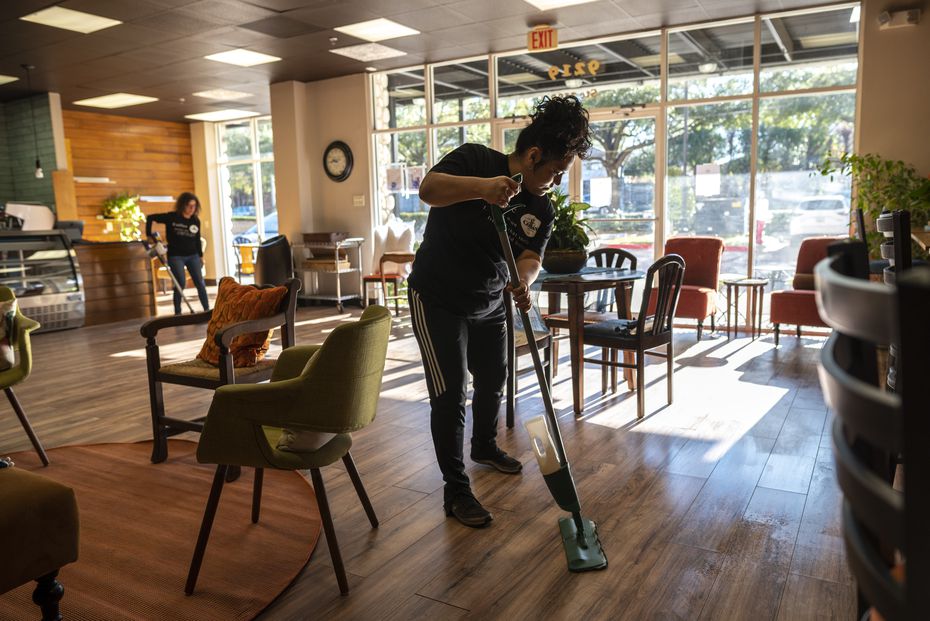 Barista Maricela Espinosa (right) mops the floor inside Well Grounded Coffee Community in...