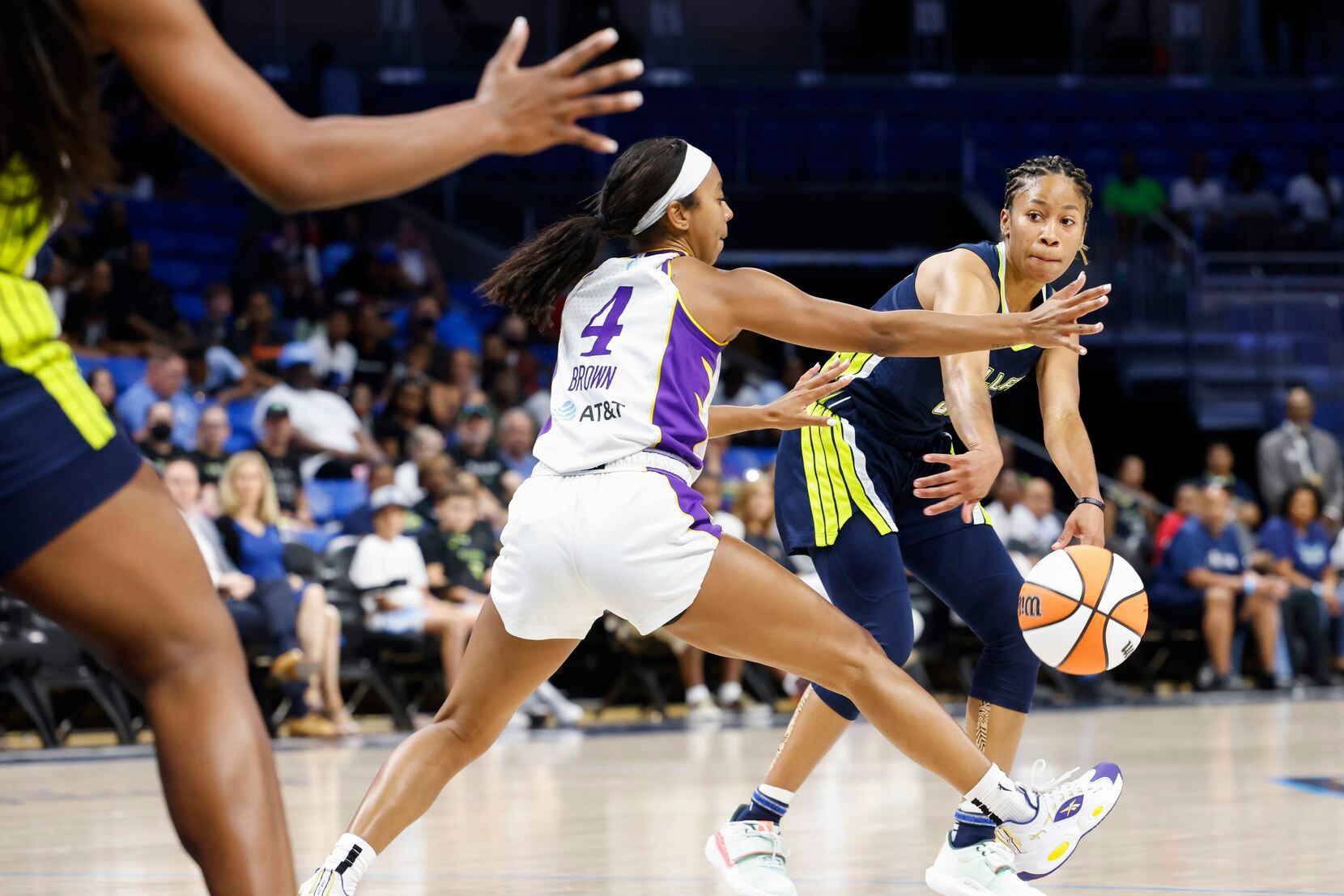Dallas Wings guard Tyasha Harris, right, passes past Los Angeles Sparks guard Lexie Brown...