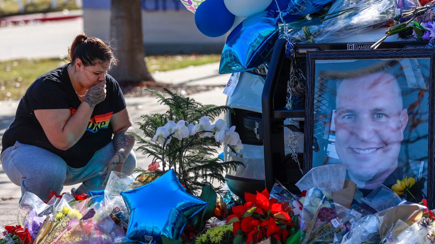 Destiny Garcia, de 23 años, se santigua poco después de dejar unas flores a nombre del policía Richard Lee Houston, quien murió el viernes en una balacera.