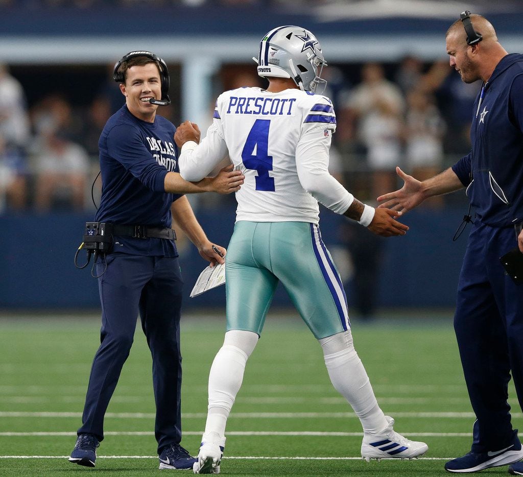 Dallas Cowboys offensive coordinator Kellen Moore (left) and offensive line coach Marc Colombo (right) celebrate with Dallas Cowboys quarterback Dak Prescott (4) after a touchdown during the second half of play at AT&T Stadium in Arlington, Texas on Sunday, September 8, 2019. Dallas Cowboys defeated the New York Giants 35-17 in the home opener.