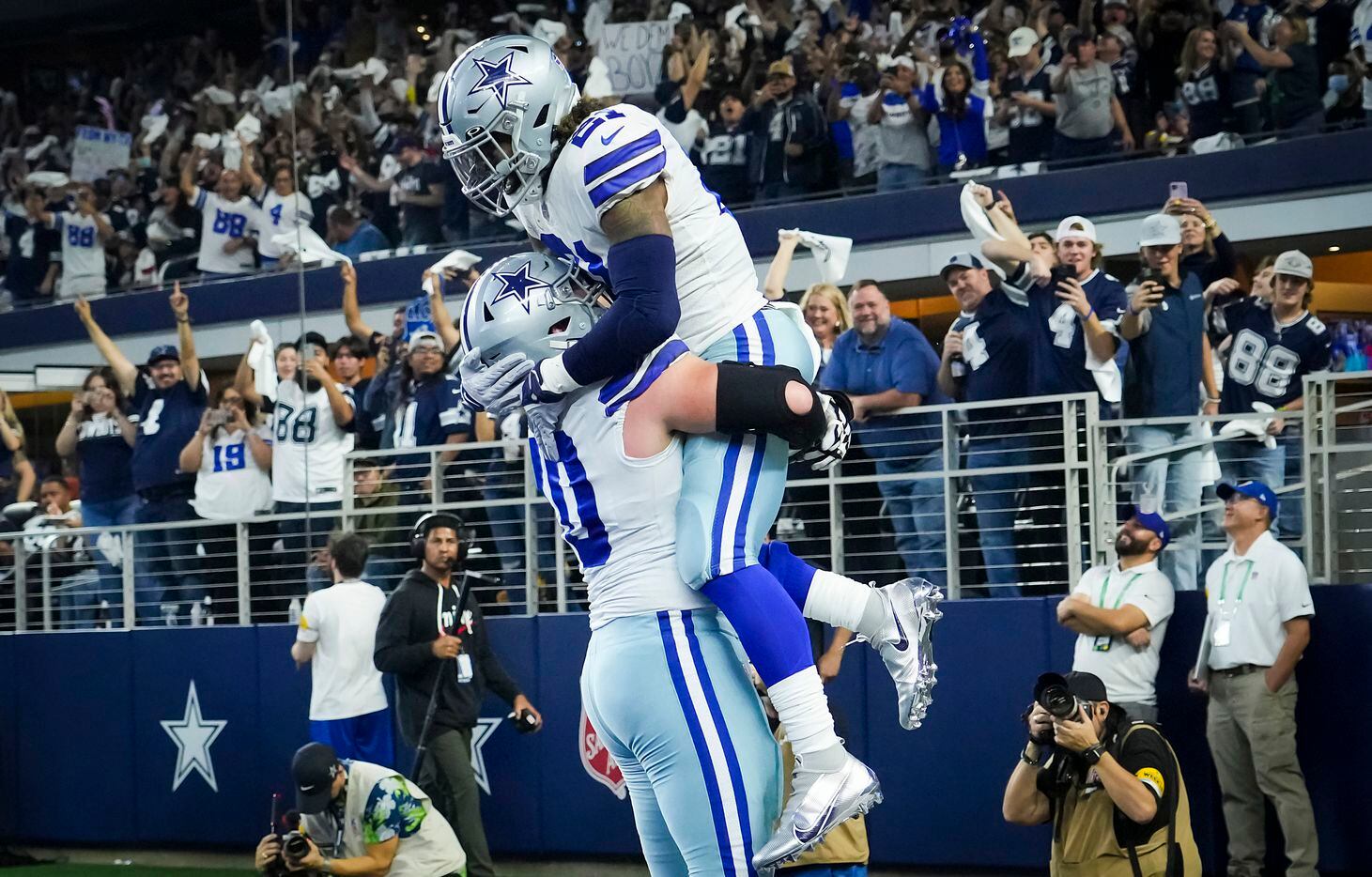 Dallas Cowboys running back Ezekiel Elliott (21) celebrates with guard Zack Martin (70) after scoring on a pass receptions during the first half of an NFL football game against the Washington Football Team at AT&T Stadium on Sunday, Dec. 26, 2021, in Arlington.