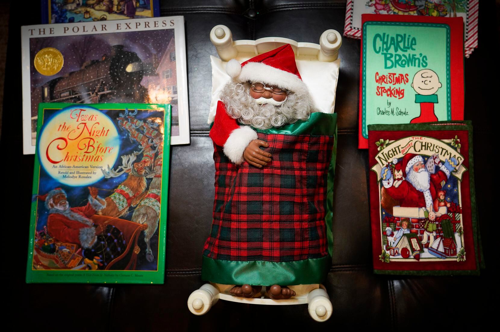 Children's books surround a snoozing Santa. Hamilton's grandchildren help her put the collection away. 