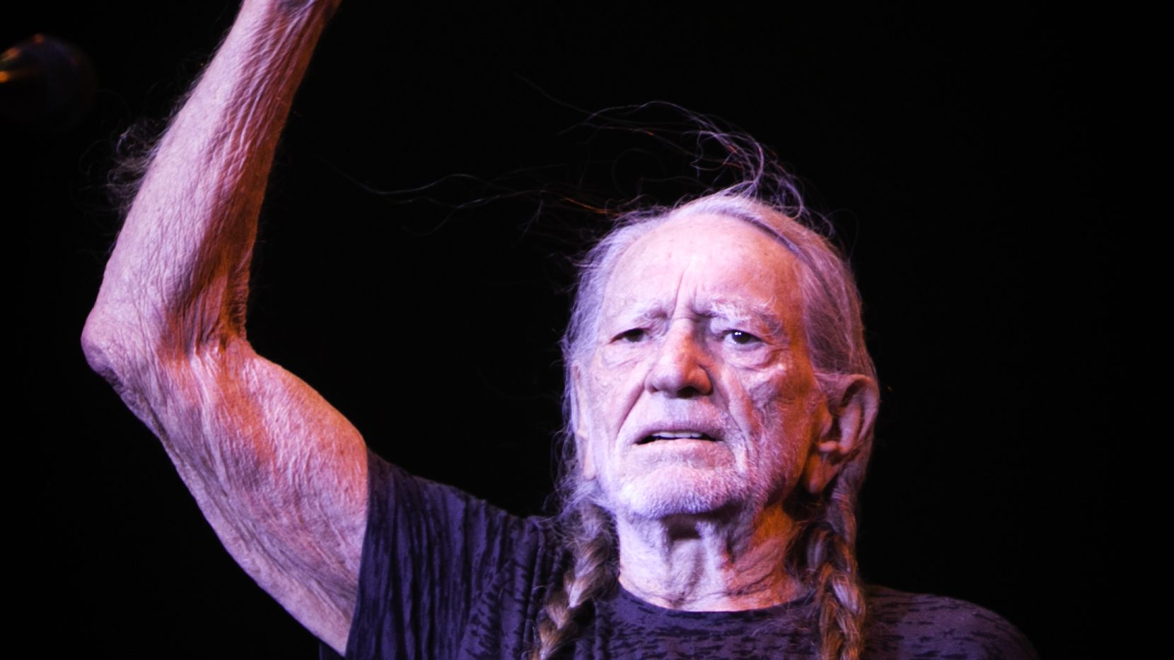 Willie Nelson greets the crowd during the Outlaw Music Festival at the Starplex Pavilion in...