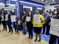 Dallas ISD staff hold signs with positions they are looking for during a job fair at Emmett...