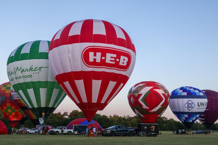 Hot air balloons inflate at the Plano Balloon Festival at Oak Point Park and Nature Preserve.