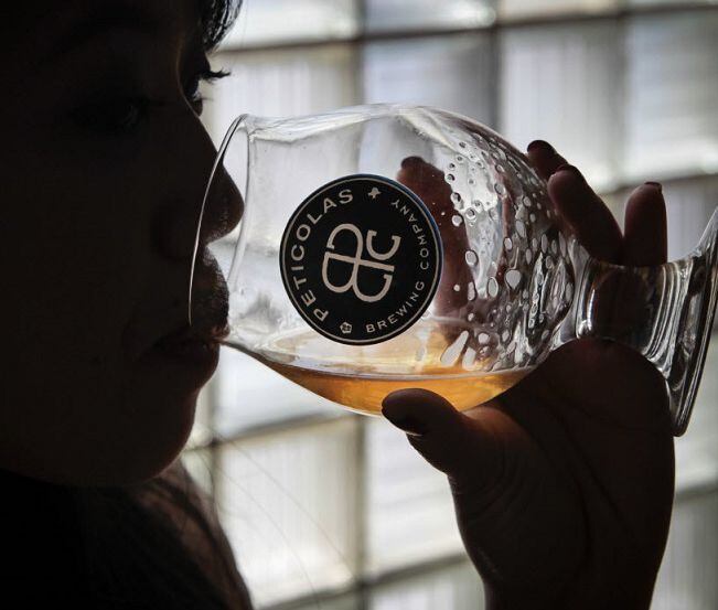 Julie Nguyen of Dallas samples a beer during an open house at Peticolas Brewing Company in...