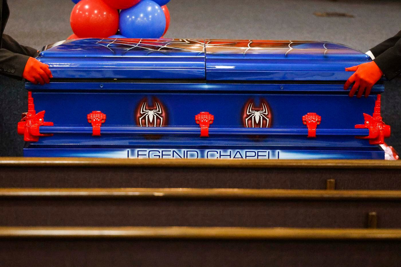 Pallbearers roll a red and blue Spider-Man themed casket of late Legend Chappell after a...