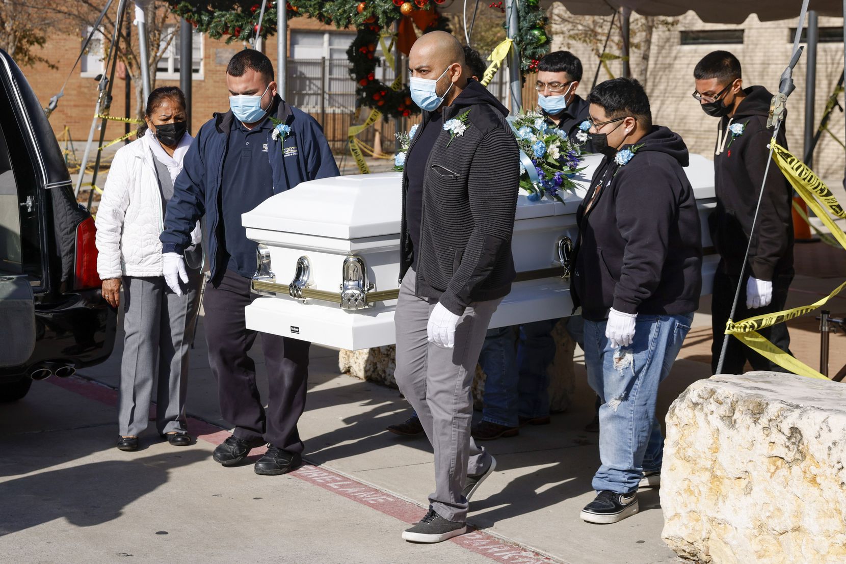 Pallbearers walk with the casket of Rafael García after his funeral Mass at Good Shepherd...