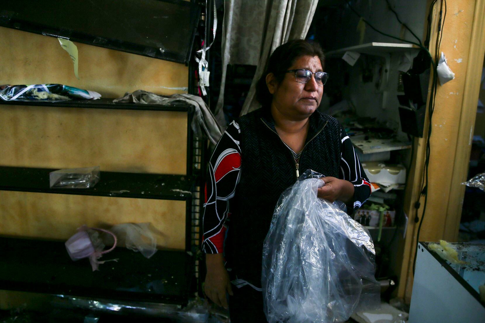 Camila Lopez retira los restos de su tienda de novias Emmanuel Bridal Shop que quedó destruida tras el paso del tornado el domingo.