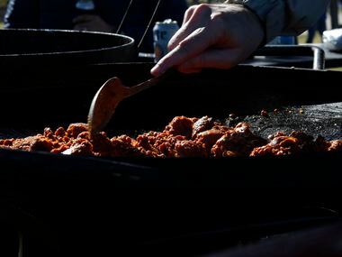 Mario Tresgonzalez store a batch of chorizo served for breakfast during a tailgating party...