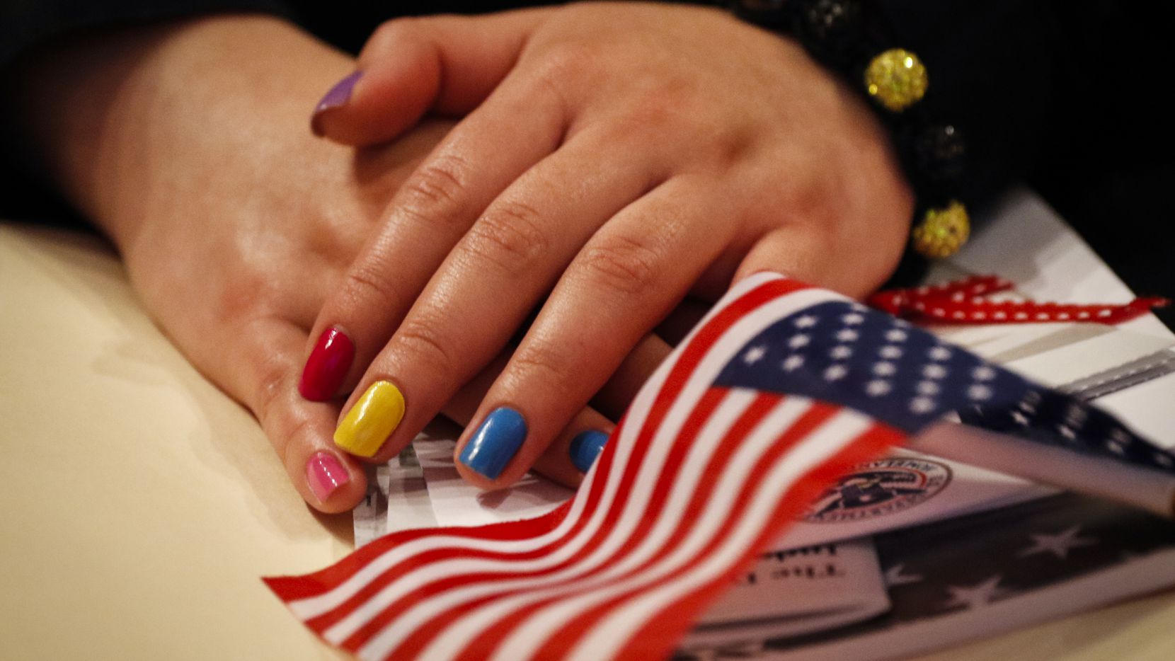 Alicia Pantoja, who is native to Mexico, hold an American flag and several documents during a U.S. Citizenship and Immigration Services naturalization ceremony for 50 immigrants from 22 different countries at the Dallas Museum of Art in Dallas on  April 6, 2015. (Jim Tuttle/The Dallas Morning News)