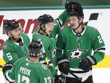 Dallas Stars left wing Jason Robertson (21) congratulates left wing Roope Hintz (right) on his third period goal against the Chicago Blackhawks at the American Airlines Center in Dallas, Tuesday, March 9, 2021. The Stars defeated the Blackhawks, 6-1.