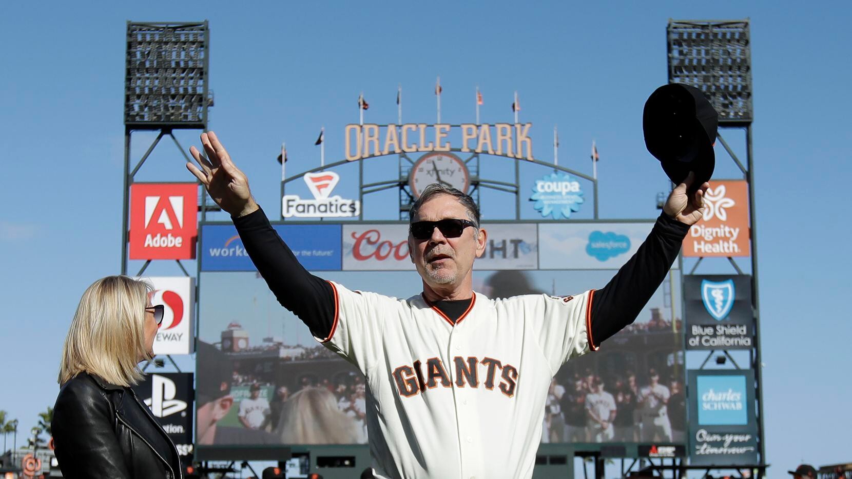 FILE - San Francisco Giants manager Bruce Bochy gestures toward fans next to his wife Kim...