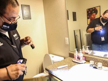 City of Mesquite Building Inspector Joe Martinez looks at the mold growing under the sink at...
