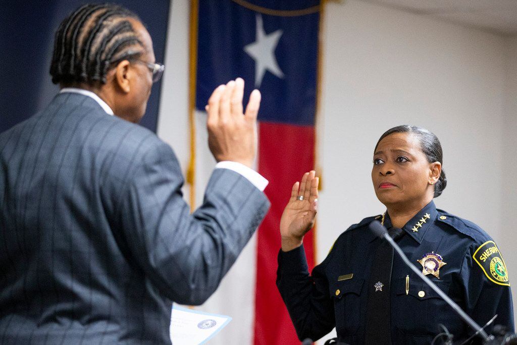 Commissioner John Wiley Price administers the oath of office to Sheriff Marian Brown on...