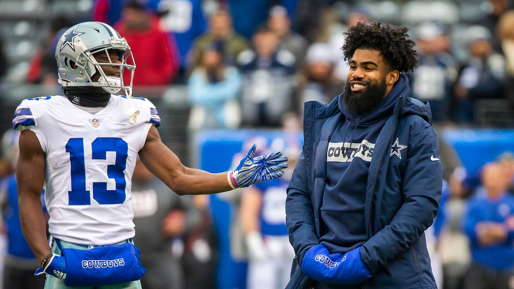 Dallas Cowboys running back Ezekiel Elliott, who was not in uniform for the game, laughs with wide receiver Michael Gallup (13) as the team warms before an NFL football game against the New York Giants at MetLife Stadium on Sunday, Dec. 30, 2018, in East Rutherford, New Jersey. (Smiley N. Pool/The Dallas Morning News)