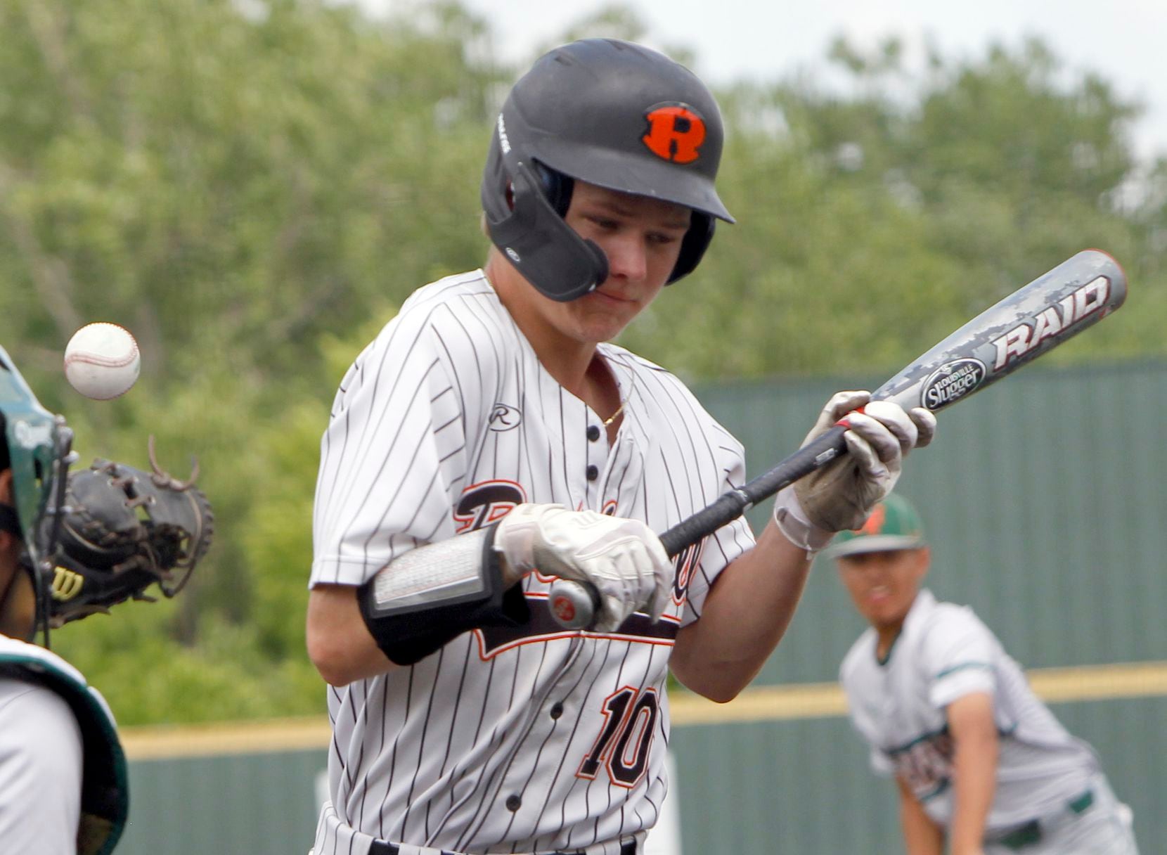 Rockwall outfielder Barrett Riebock (10) winces after being hit by a pitch while batting...