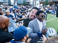 Former Dallas Cowboys player Michael Irvin hands out autographs during the recording of...