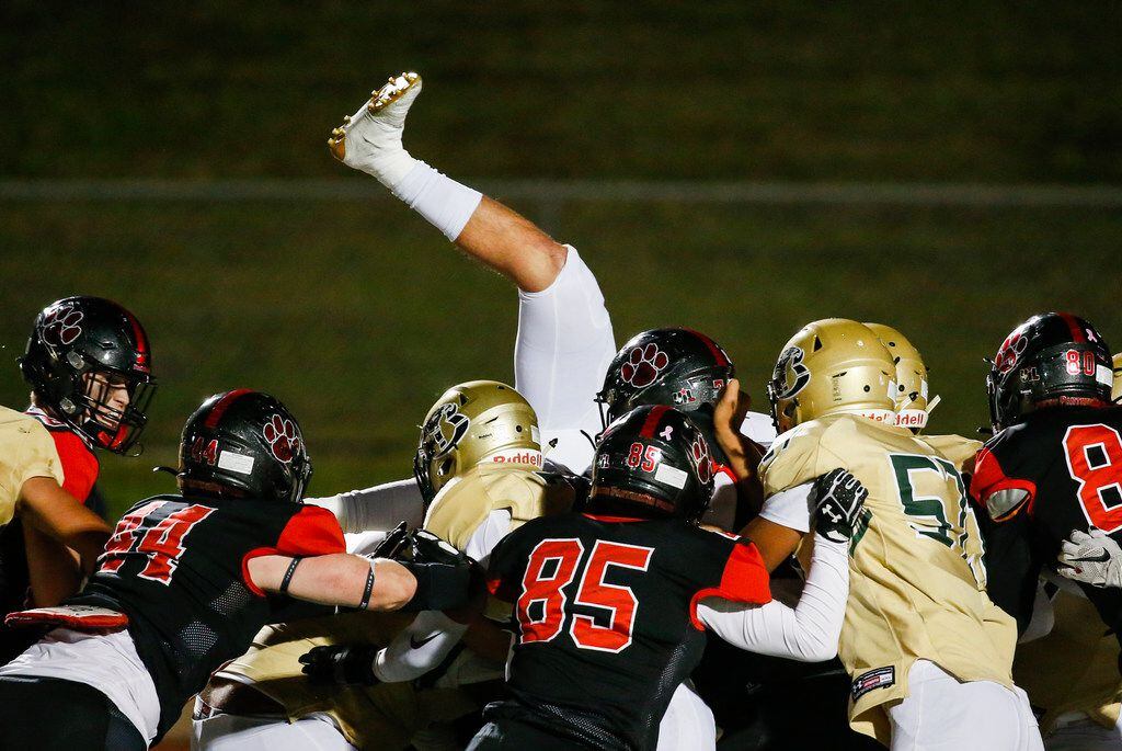 A Birdville player is upended while working to stop a Colleyville Heritage conversion during...