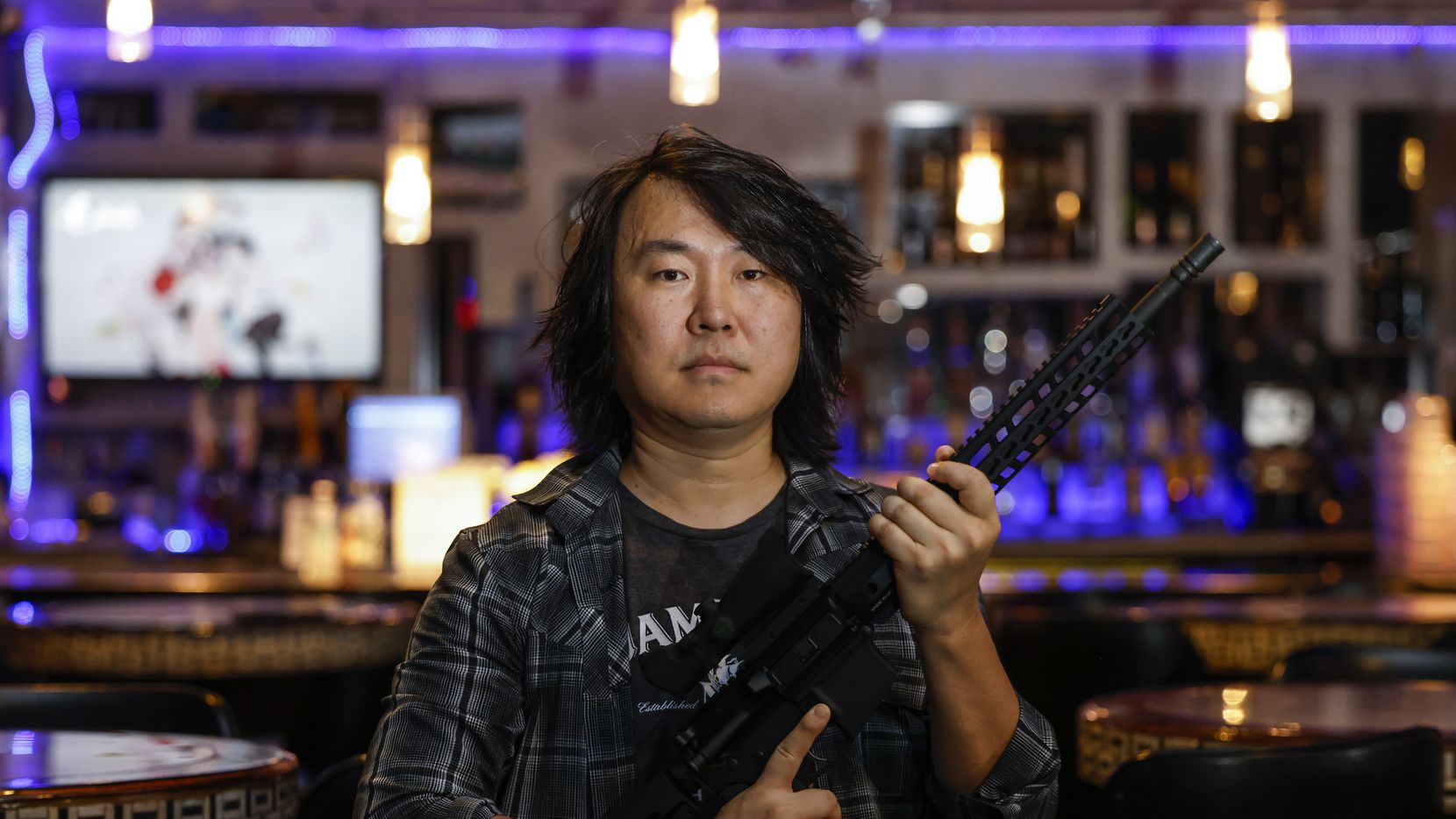 Encore Family Karaoke owner Jin Shin poses for a portrait with his semi-automatic AM-15 on...