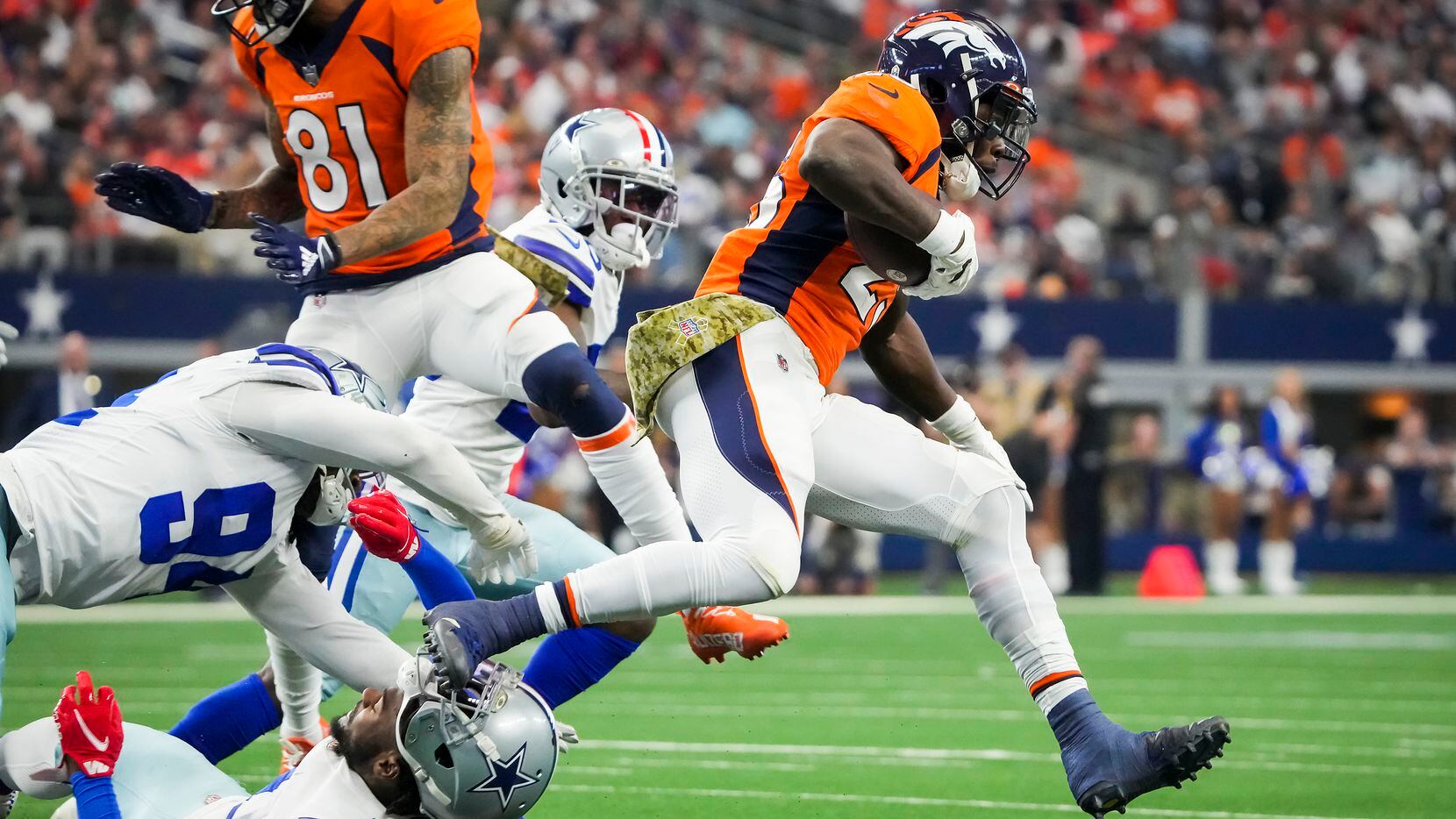 Denver Broncos running back Melvin Gordon (25) gets past Dallas Cowboys defensive back...
