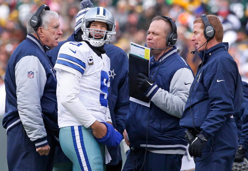 Dallas Cowboys quarterback Tony Romo (9) confers with Scott Linehan and head coach Jason...