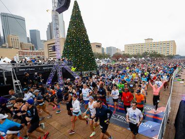 Runners cross the BMW Dallas Marathon start line in front of Dallas City Hall on Sunday,...