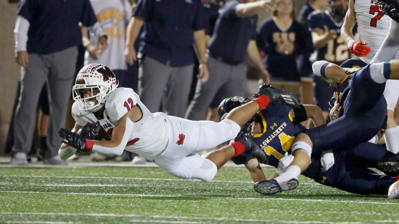 Melissa’s Ashton Mitchell Johnson (12) dives for extra yardage as he is tackled by Stephenville’s Hyson Foreman(14) during the first half of a Class 4A Division I Region II final high school football game in Bedford, Texas on Friday, Dec. 3, 2021. (Michael Ainsworth/Special Contributor)