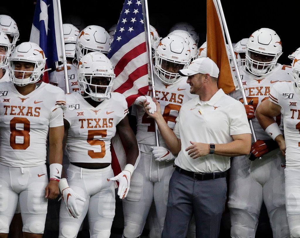 Texas head coach Tom Herman, center, prepares to takes the field with quarterback Sam...