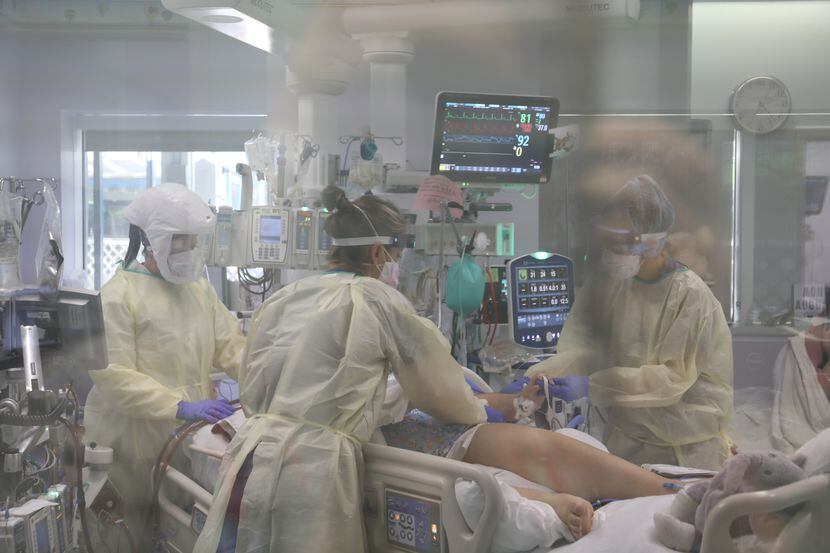 Un grupo de enfermeras cuida a un niño con covid-19 en la unidad de cuidados intensivos del...