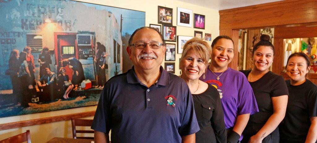 The family at Herrera's Cafe at 3311 Sylvan Avenue in Dallas, with an enlarged vintage photograph of the restaurant from the 1970s in the background. Left to right are Larry Ontiveros (grandson), Nora Ontiveros (granddaughter), DeeAnn Ontiveros (great granddaughter), Brittany Olivarez (great great granddaughter), and Melisa Rivas (great grand daughter), 
photographed on September 19, 2018.